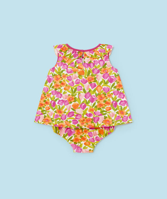 Bright and cheerful sleeveless baby romper featuring an all-over floral pattern in pink, orange, and green hues