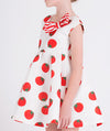 ecru dress with tomato prints and a red and white striped bow on the front