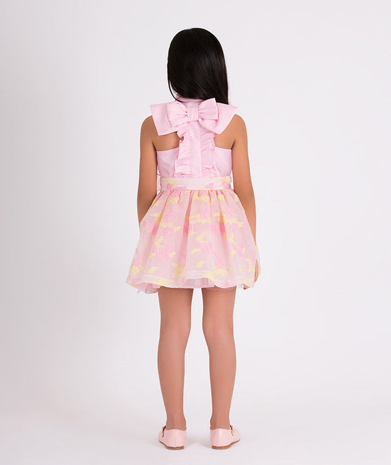 pink blouse with a bow on the back and floral organza skirt