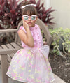 pink ruffled blouse and pastel skirt with a bow