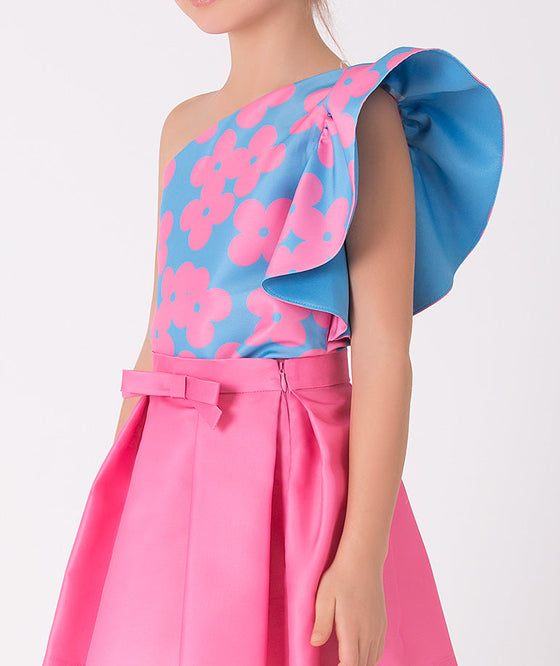 blue one shoulder blouse with pink flower prints and a pink skirt